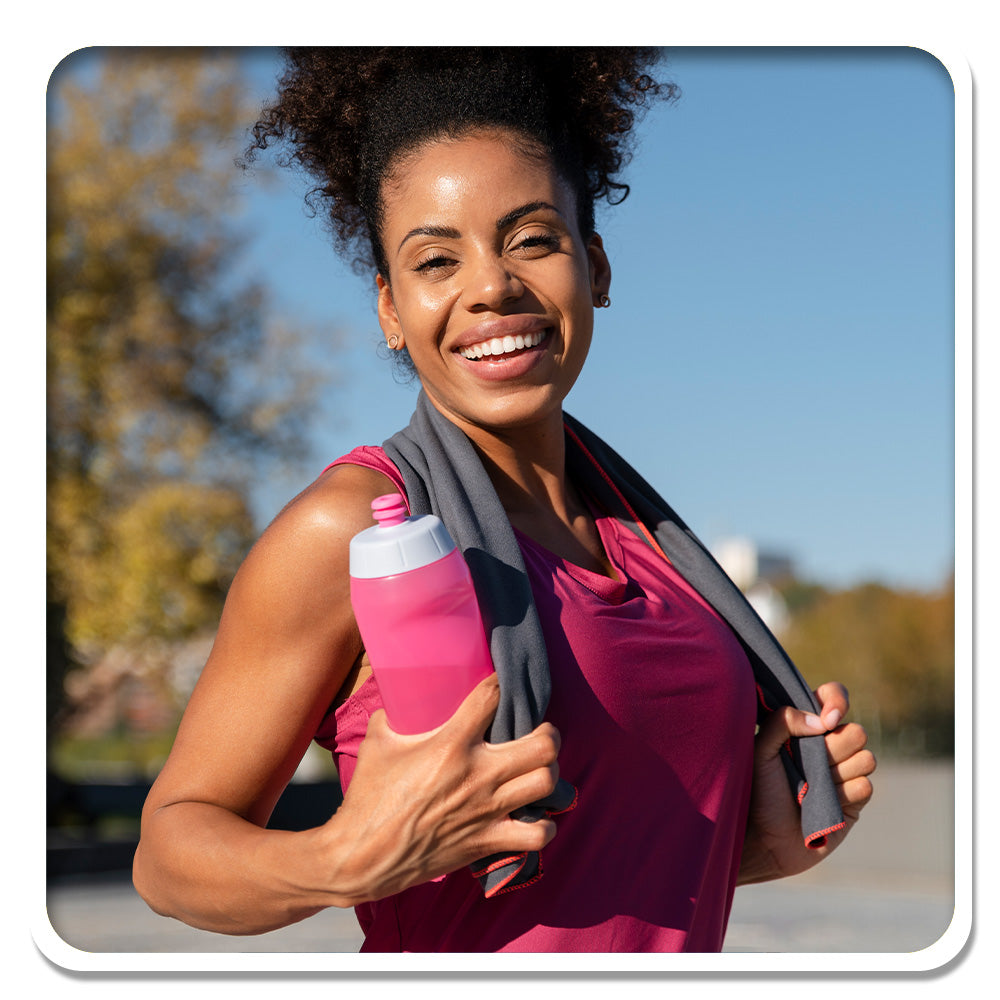 Smiling woman with water bottle, embracing wellness with Lily & Loaf's support for an active lifestyle.