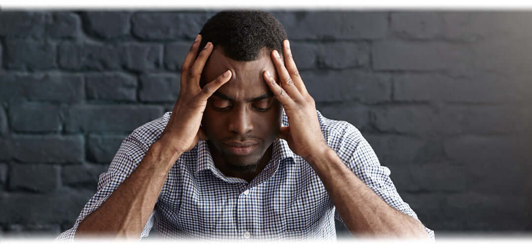 A person holding their head in discomfort, indicating a headache. The image illustrates the concept of dealing with headaches and the need for relief or remedies