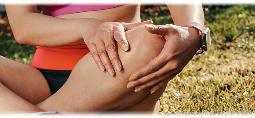 Image of a person holding their knee in discomfort, indicating joint pain.