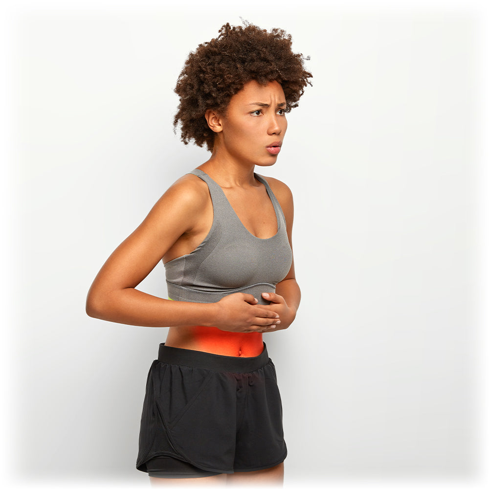 Athletic woman with stomach pain, highlighting the need for proper digestion support.