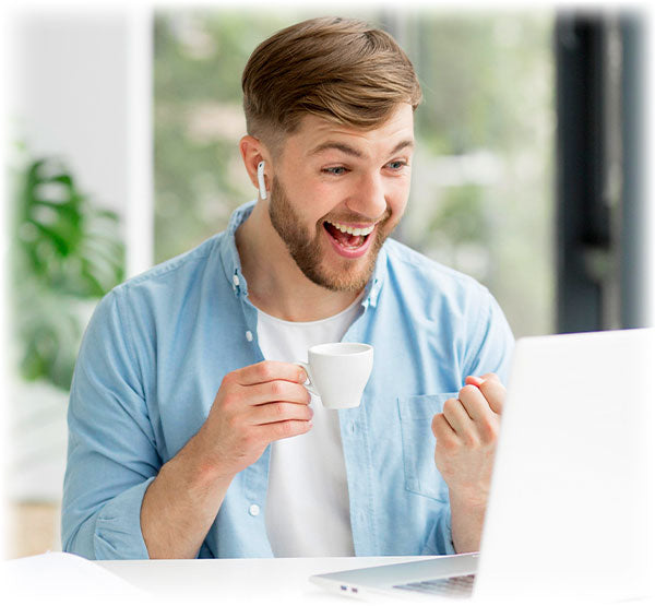 Cheerful man with coffee engaging in an online Lily & Loaf wellness webinar.